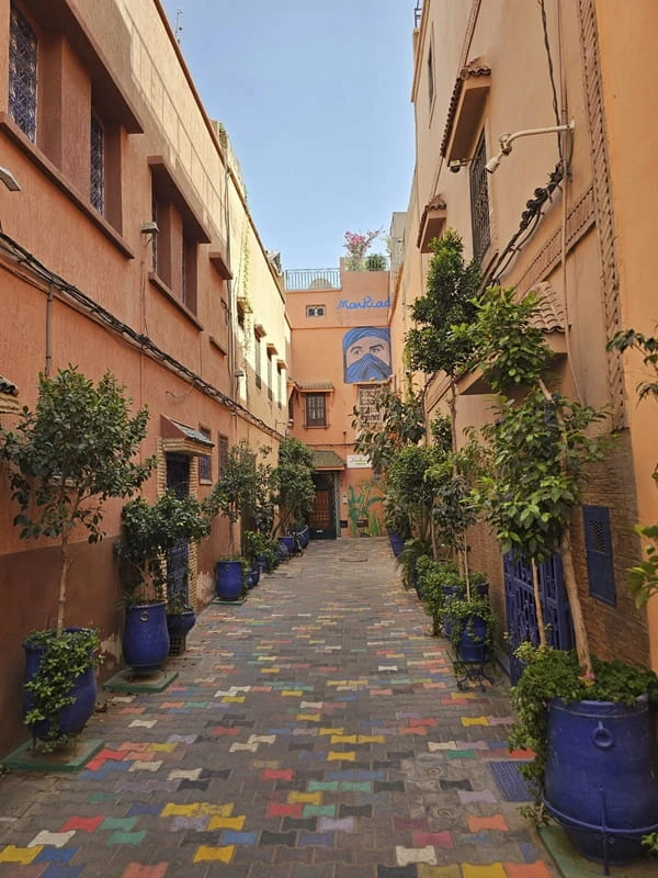 Traditionelle Gasse in der Medina von Marrakesch mit Riad-Eingängen und kunstvollen Details.